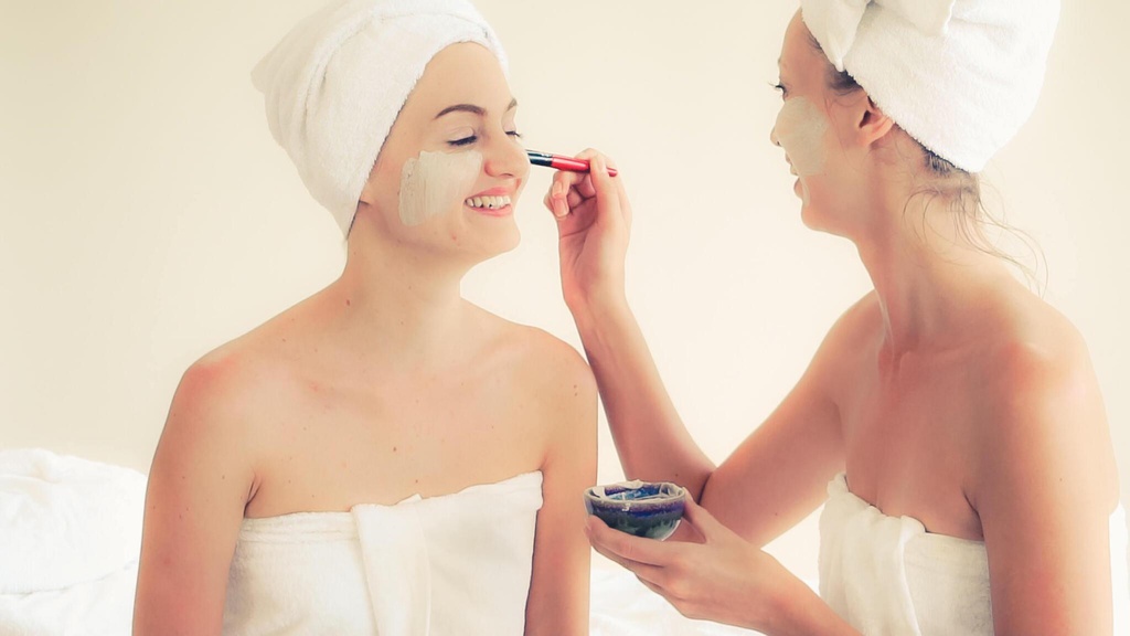 Beautiful woman having a facial cosmetic scrub treatment at wellness spa. 